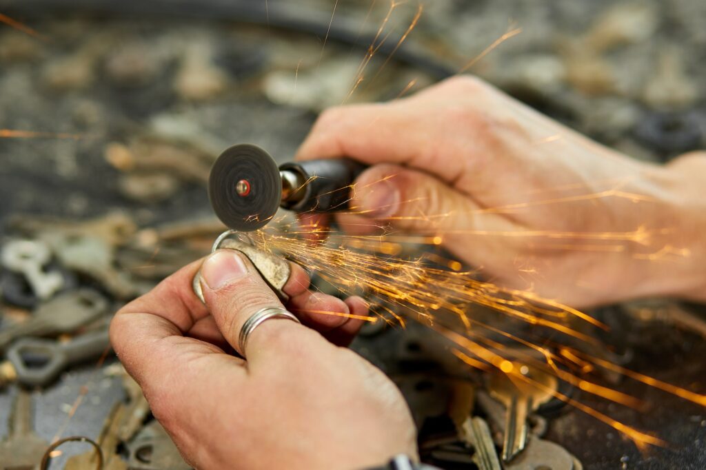 Locksmith in workshop makes new key, use grinding engraving machine
